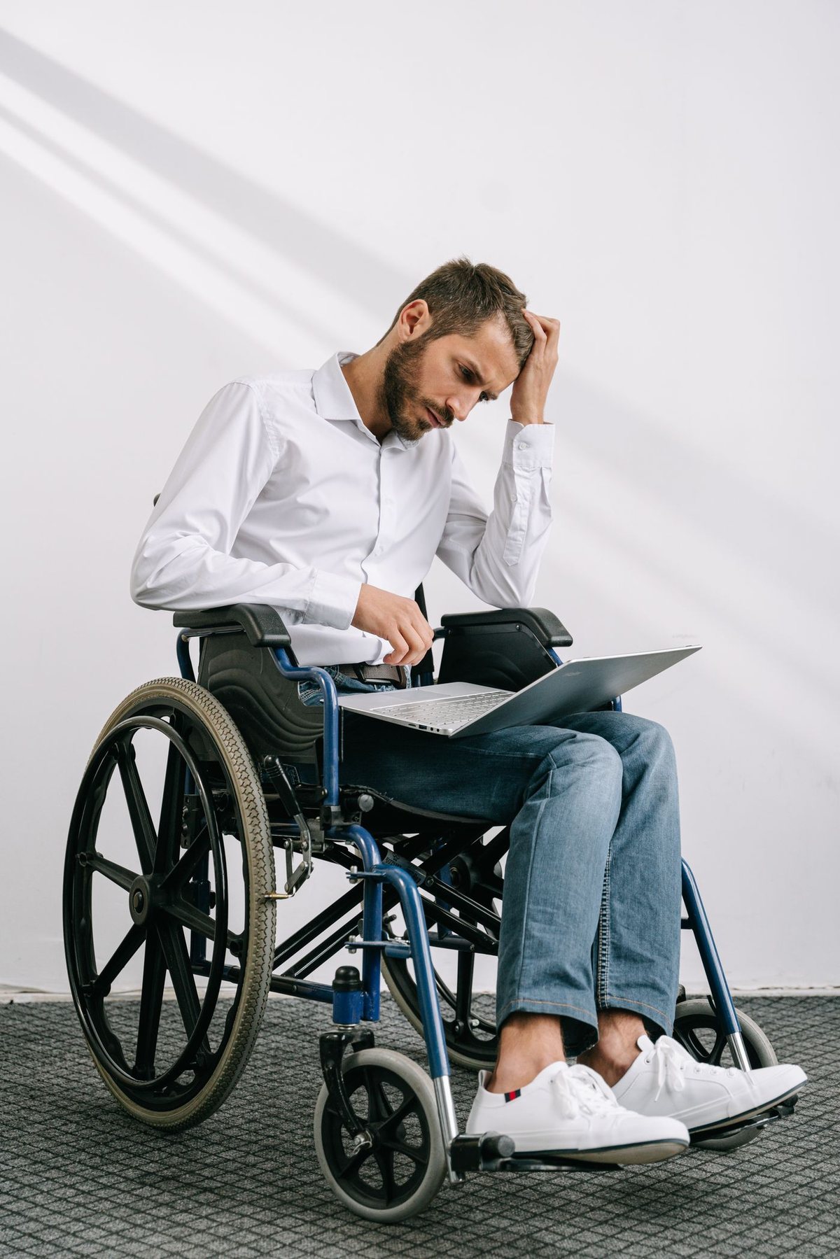 A wheelchair user working independently on a laptop