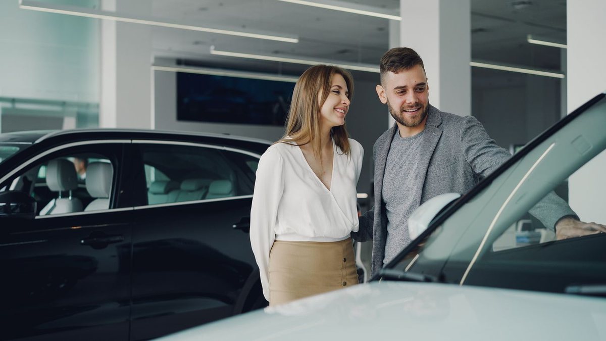 A couple exploring a new car at a dealership