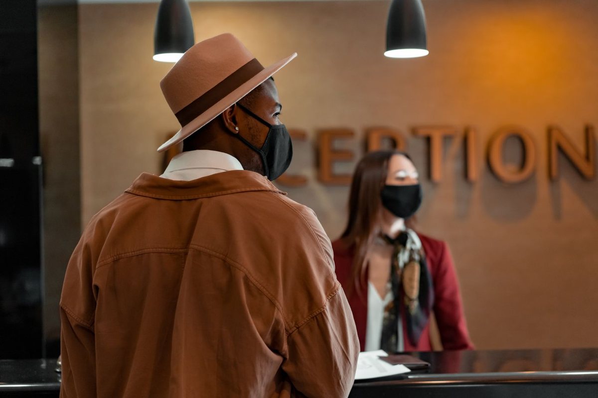A visitor being welcomed at a reception counter