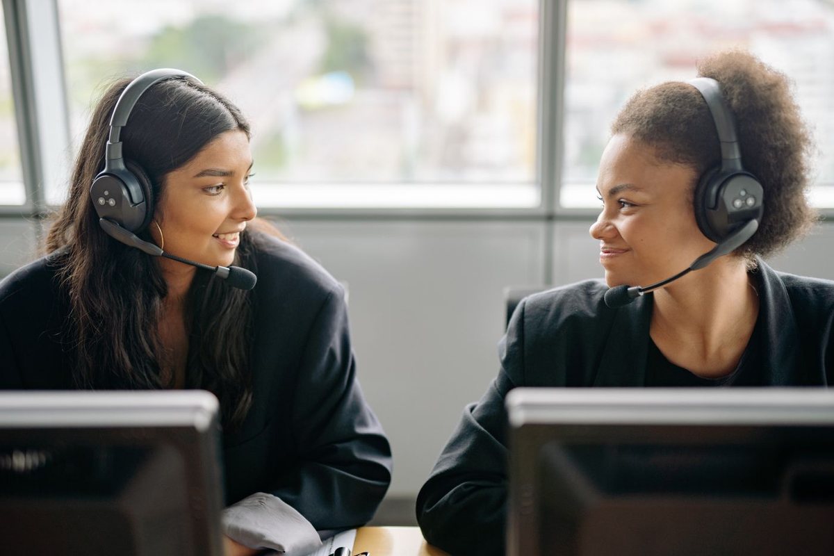 Two customer support colleagues wearing headsets