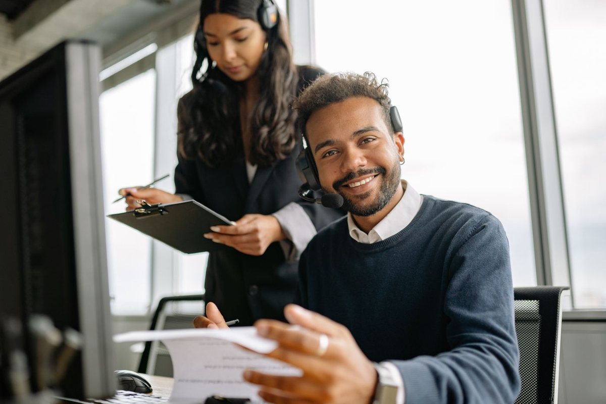 Smiling customer advisor discussing paperwork with a colleague